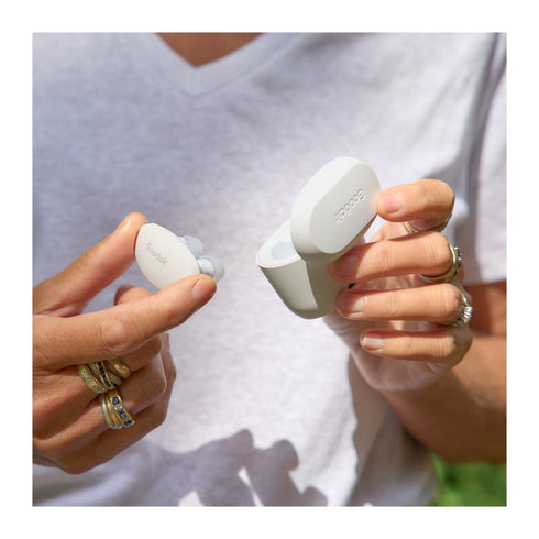 A pair of hands holding the Goodair Nosebuds and charging case