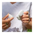A pair of hands holding the Goodair Nosebuds and charging case