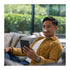 A man wearing Goodair Nosebuds while sitting on a couch reading