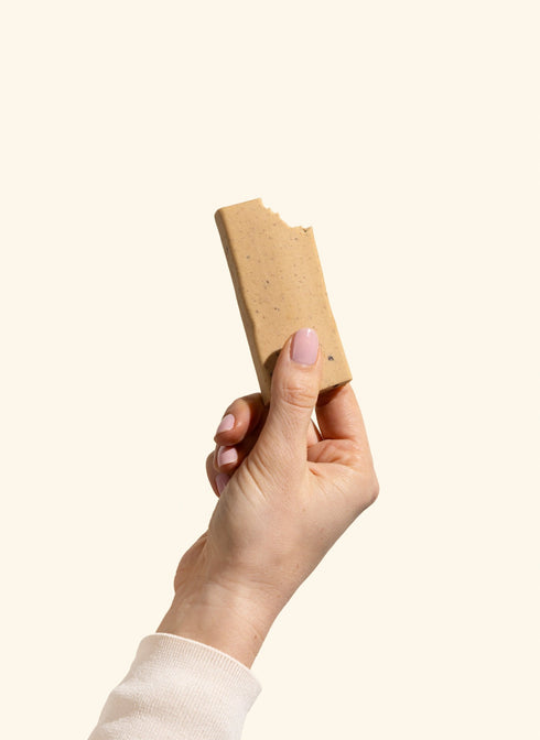 Betty Caramel Cookie Dough Protein Bar unwrapped, held in hand