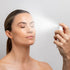 Image of lady spraying the Collagen Hydra Multi Mist 50ml onto her face with eyes closed