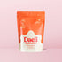 A stand-up pouch of Daeli Hydration Salted Mango sugar-free electrolyte powder, featuring a bright orange top and bottom with a white central splash shape and red brand lettering, set against a solid light pink background.
