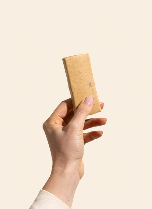 Betty Strawberry Cheesecake Protein Bar unwrapped, held in hand