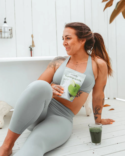 Image of woman with SuperGreens Top 7 Super Greens in glass