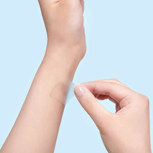 Image of a person placing a sleep patch on their wrist before bed