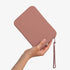 The Strapsicle Clutch in Caramel, Large size, held in one hand
