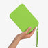 The Strapsicle Clutch in Neon Zest, Regular size, held in one hand