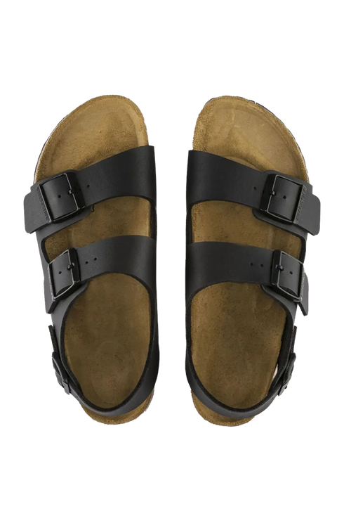 Pair of brown sandals with black straps on a white background
