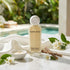 Nude Kiwi Brightening Day Cream bottle on marble beside jasmine flowers and licorice root, with a dish of the cream