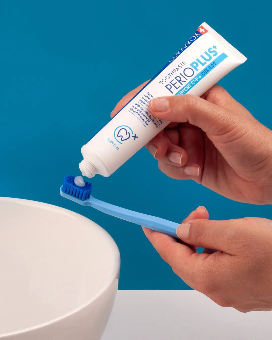 Curaprox Perio plus support toothpaste being squeezed onto a toothbrush