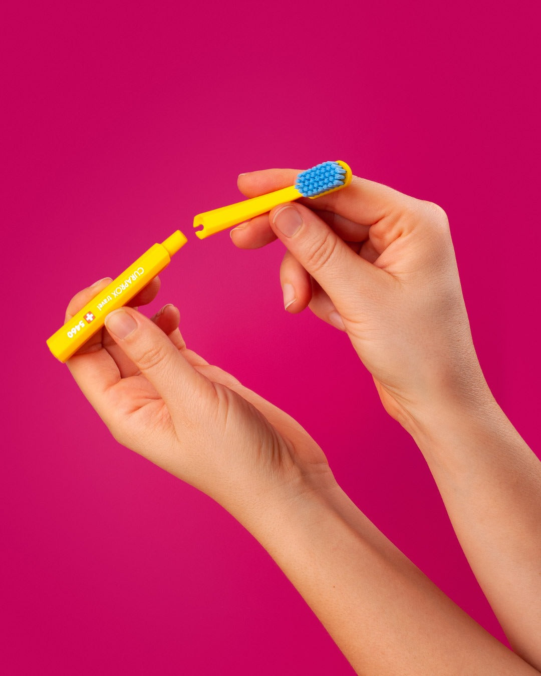 A Curaprox travel set brush head being fitted to the handle
