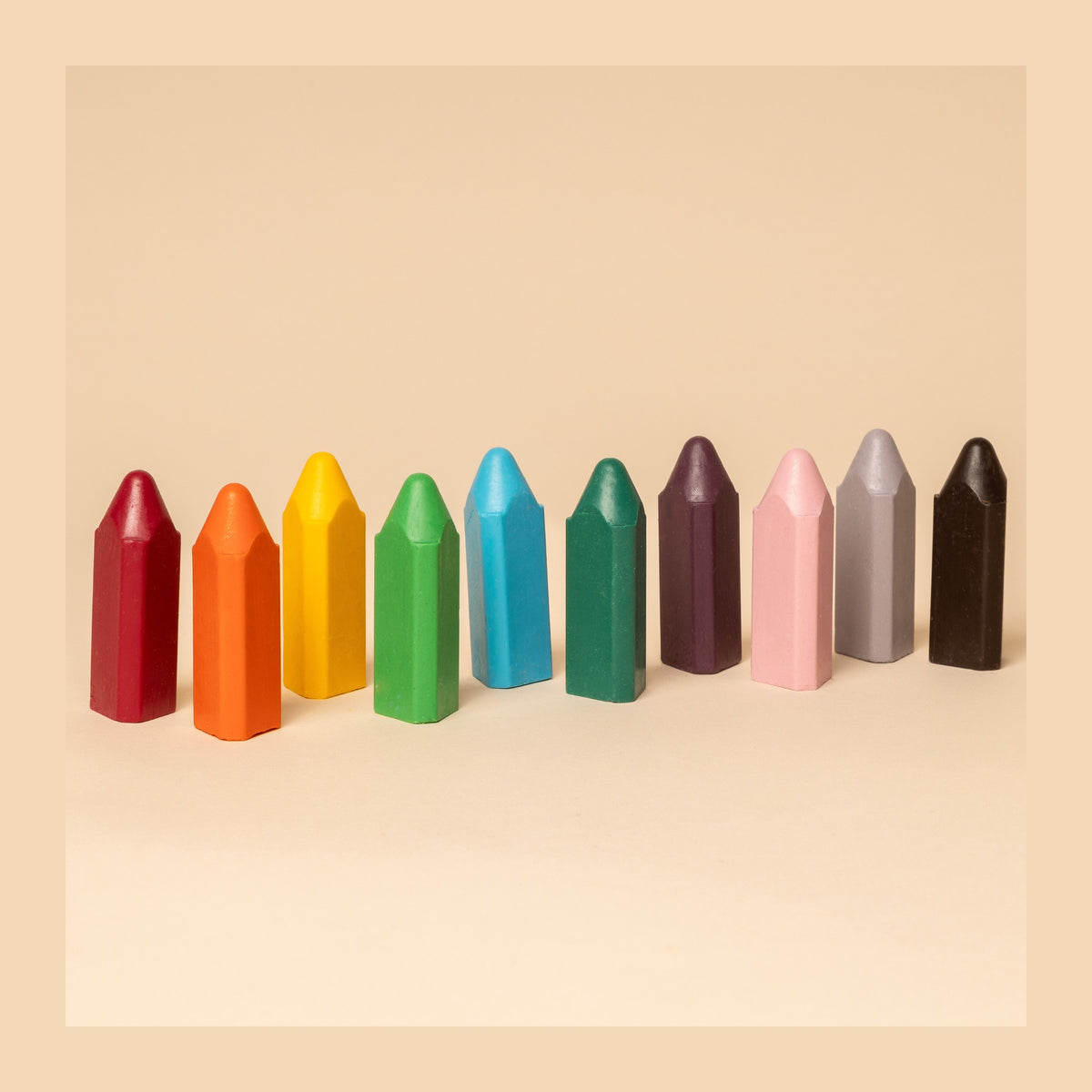 The ten triangular bath crayons standing in a row in all ten colours