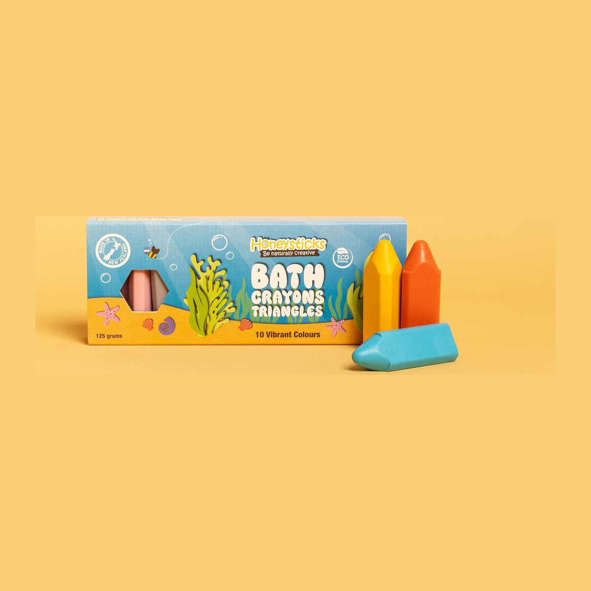 The Bath Crayon Triangles box on a yellow background with a crayon beside it