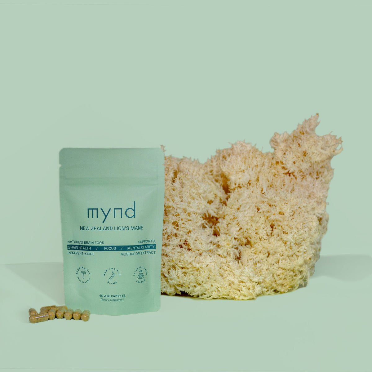 Mynd Lion's Mane capsule pouch beside a whole Lion's Mane mushroom