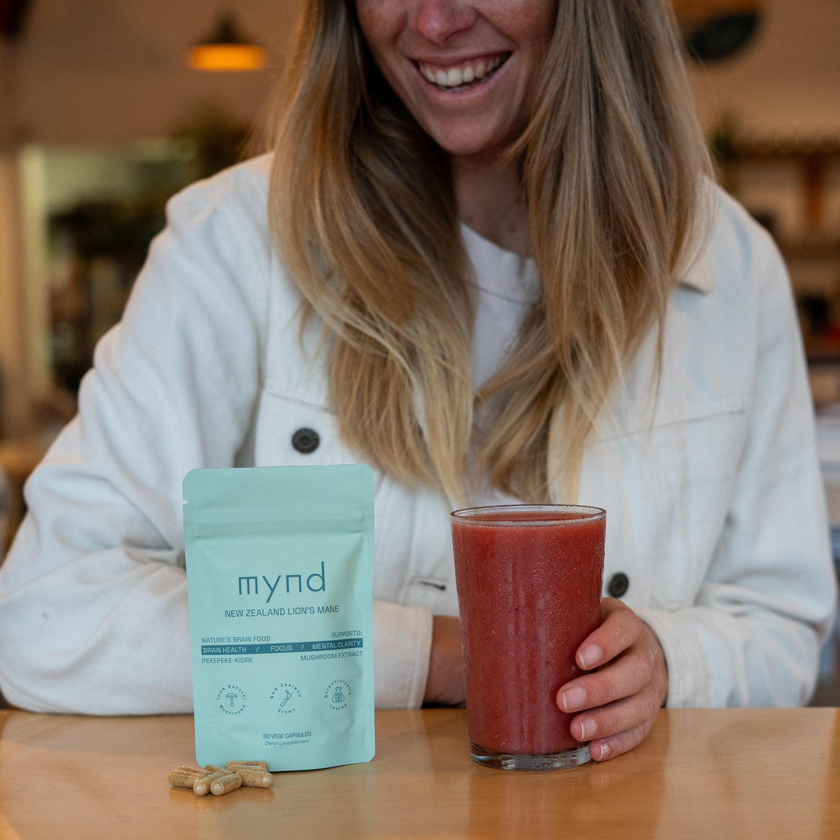 Mynd Lion's Mane capsules on a table with a smoothie