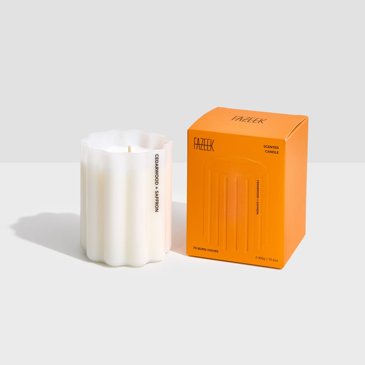 Fazeek Wave Candle in Cedarwood and Saffron, rippled white glass with the scent name on the side