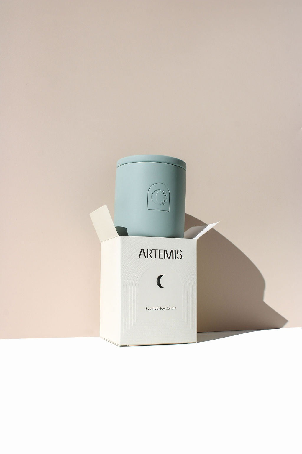 Artemis Longitude soy candle in a pale blue vessel beside its box
