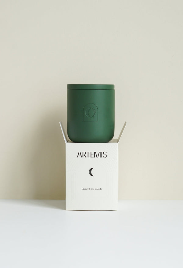 Artemis Under The Mistletoe soy candle in a deep green vessel beside its box