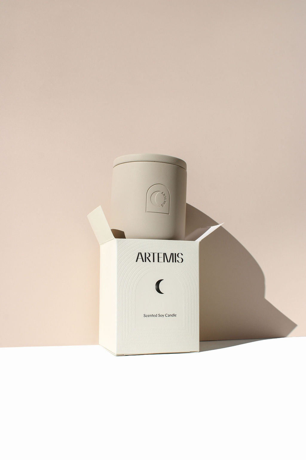 Artemis Equinox soy candle in a sand-coloured vessel beside its box