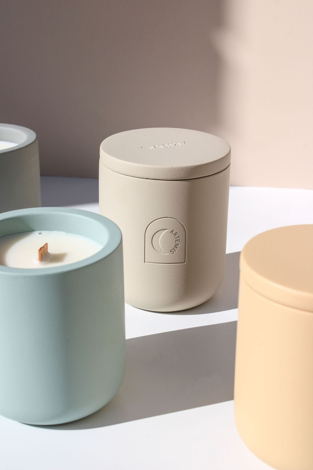Artemis Equinox candle burning with the lid set beside it