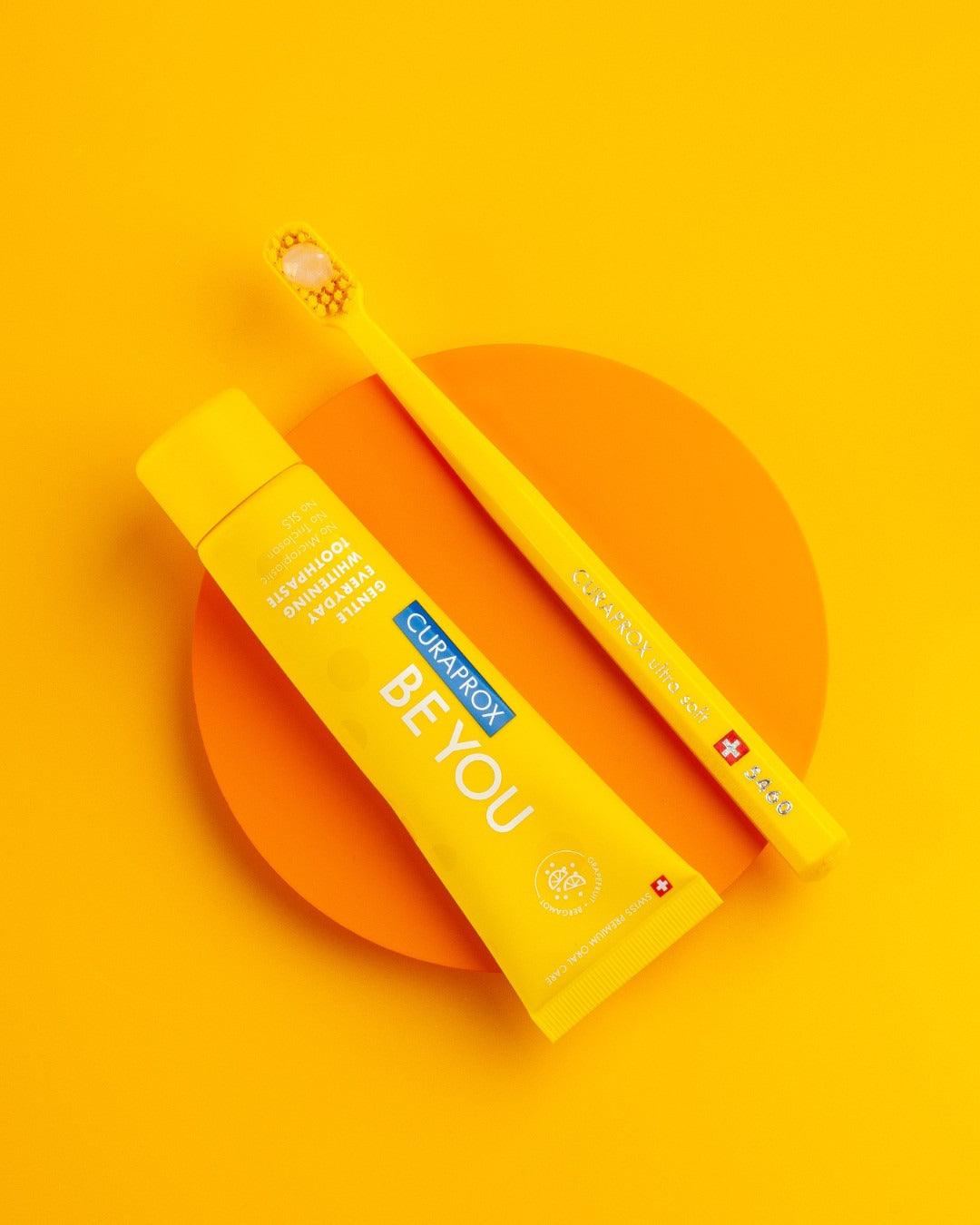 Curaprox Be you Grapefruit and Bergamot tube and carton on an orange background
