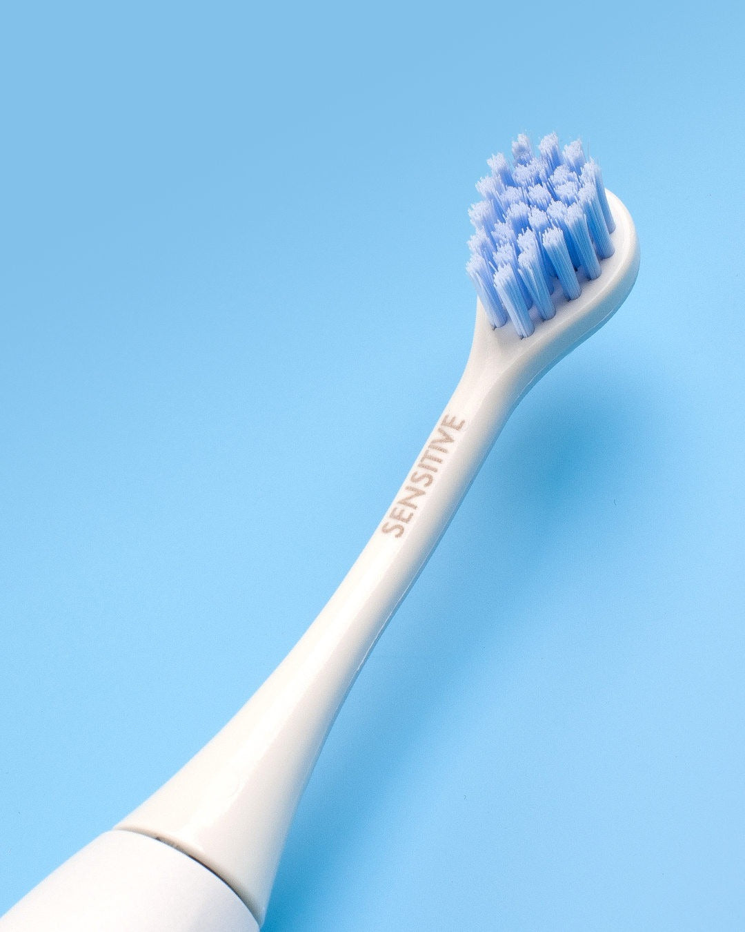 Curaprox Hydrosonic sensitive brush head on a blue background