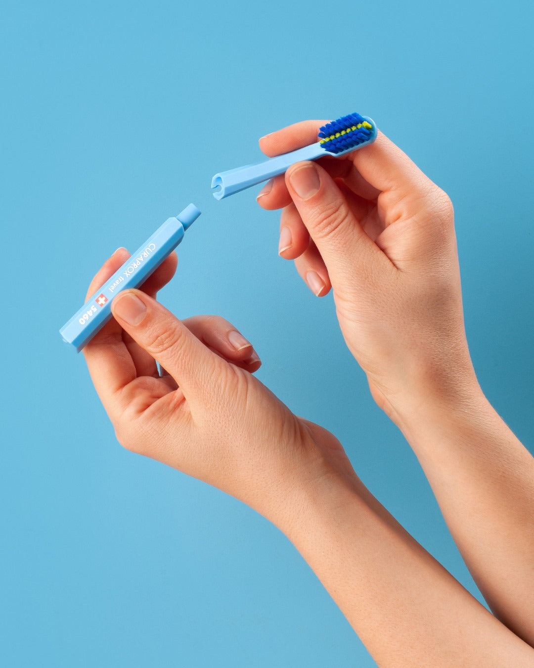 A blue Curaprox ortho travel brush head being fitted to the handle