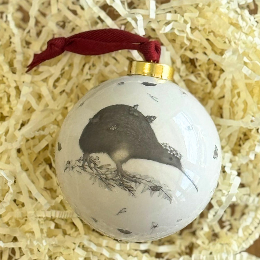 Ceramic Christmas bauble with a brown kiwi walking through native foliage