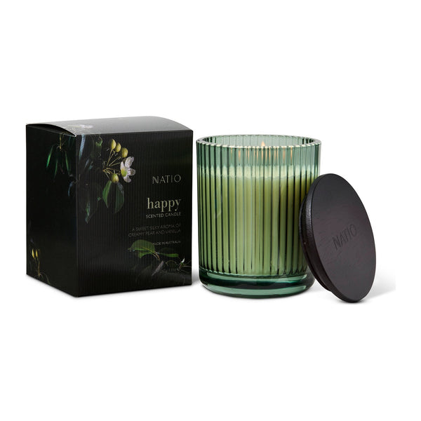 Natio Happy Scented Candle with its lid off beside the box