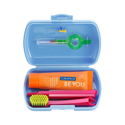 Curaprox travel set open, showing the toothbrush, toothpaste and interdental brushes, shown in blue
