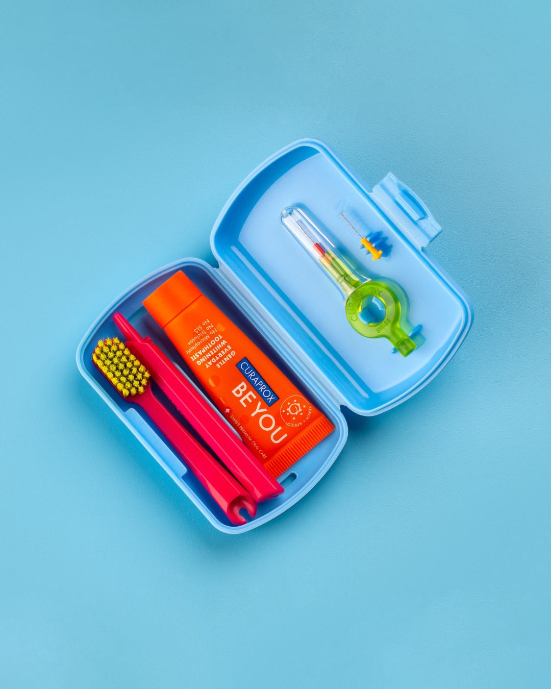 Curaprox travel set case open on a blue background