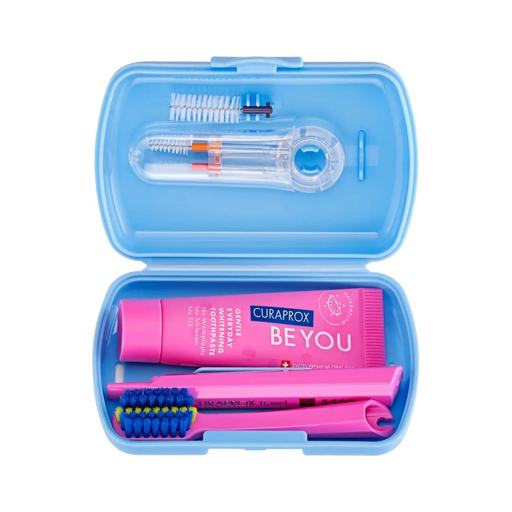Curaprox ortho travel set in blue, open to show the toothbrush, toothpaste and interdental brushes
