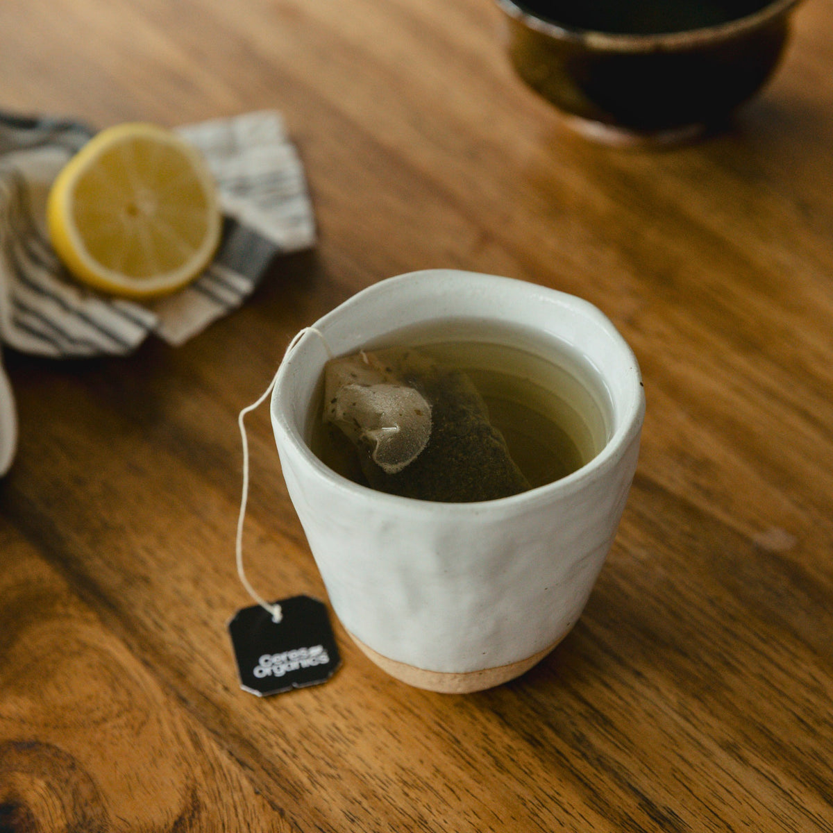 A cup of Lemon & Ginger Herbal Tea with the tea bag