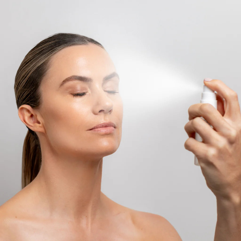 Image of lady spraying the Collagen Hydra Multi Mist 50ml onto her face with eyes closed