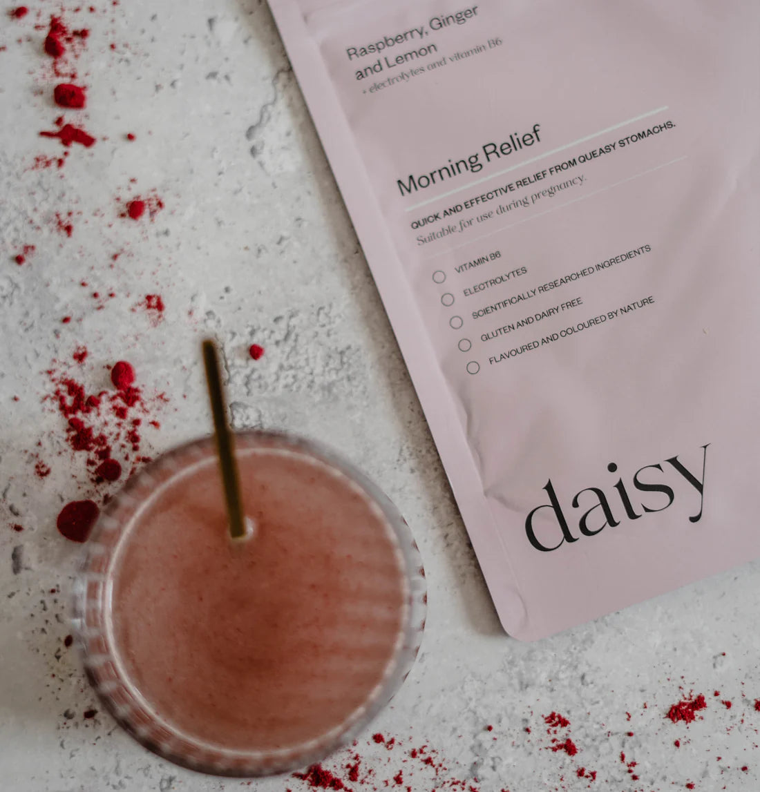 Image of the powder mixed into a glass of water. the drink is peachy in colour