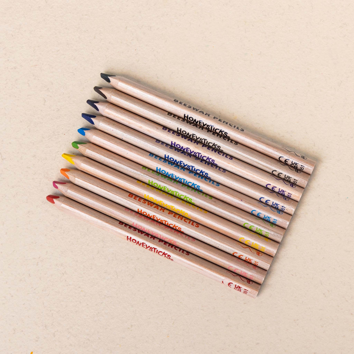 The ten jumbo triangle pencils laid in a row on cream