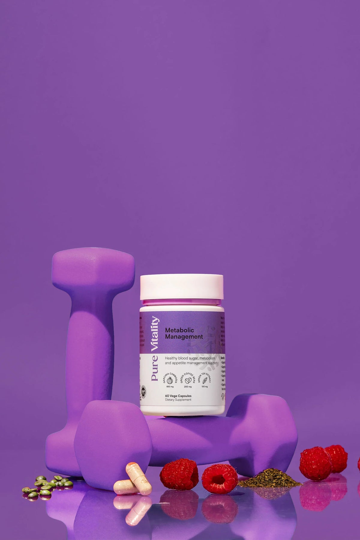 Bottle of Metabolic Management 60caps against a solid purple background with some of the ingredients around it in it's natural form