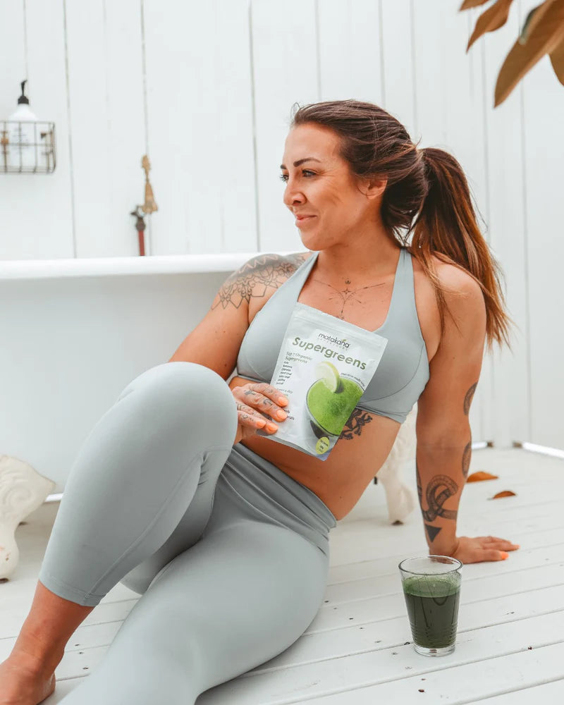 Image of woman with SuperGreens Top 7 Super Greens in glass