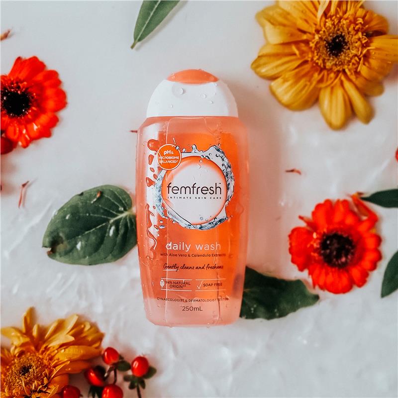 Femfresh Daily Wash bottle laid flat among calendula flowers