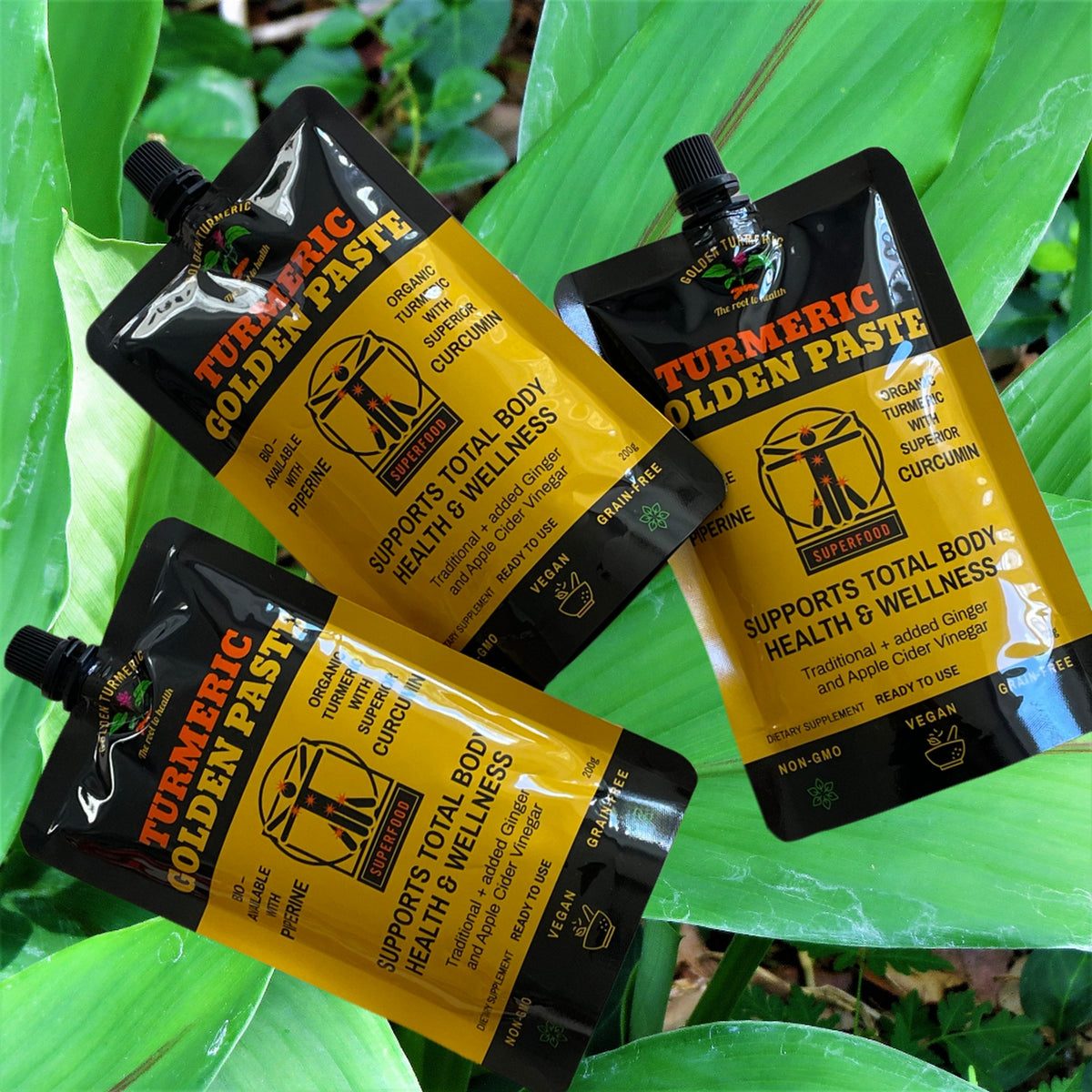 Turmeric Golden Paste pouches with fresh turmeric root on banana leaves