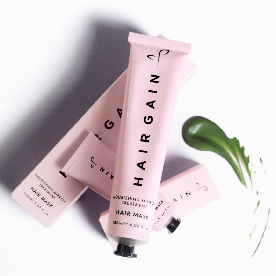 Two Hair Gain Hair Mask tubes with a swatch of the green mask