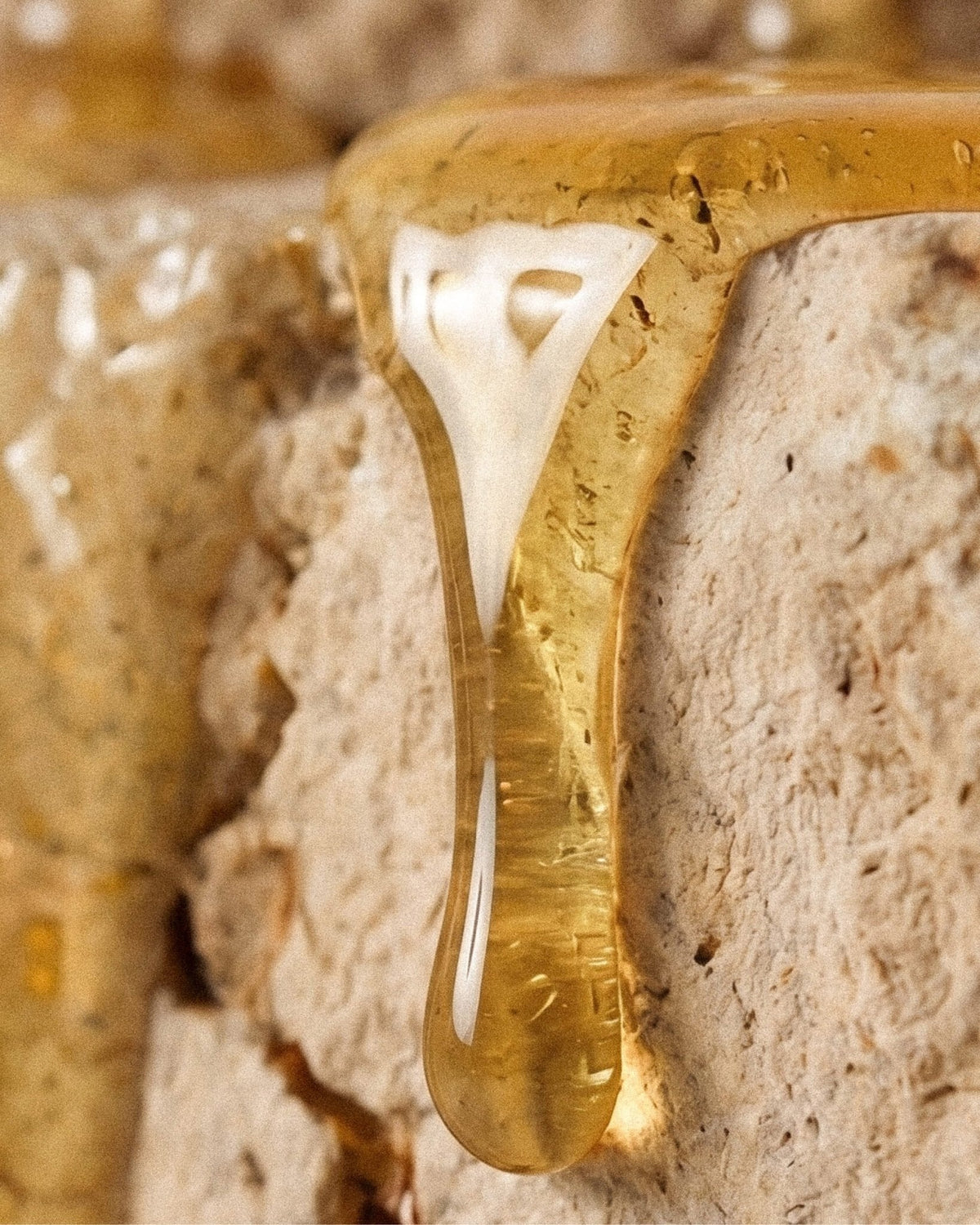 Manuka honey drizzled over bread, the honey used in the cream