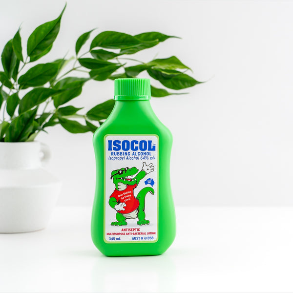 Isocol Rubbing Alcohol Antiseptic Lotion 345ml bottle on white beside a plant