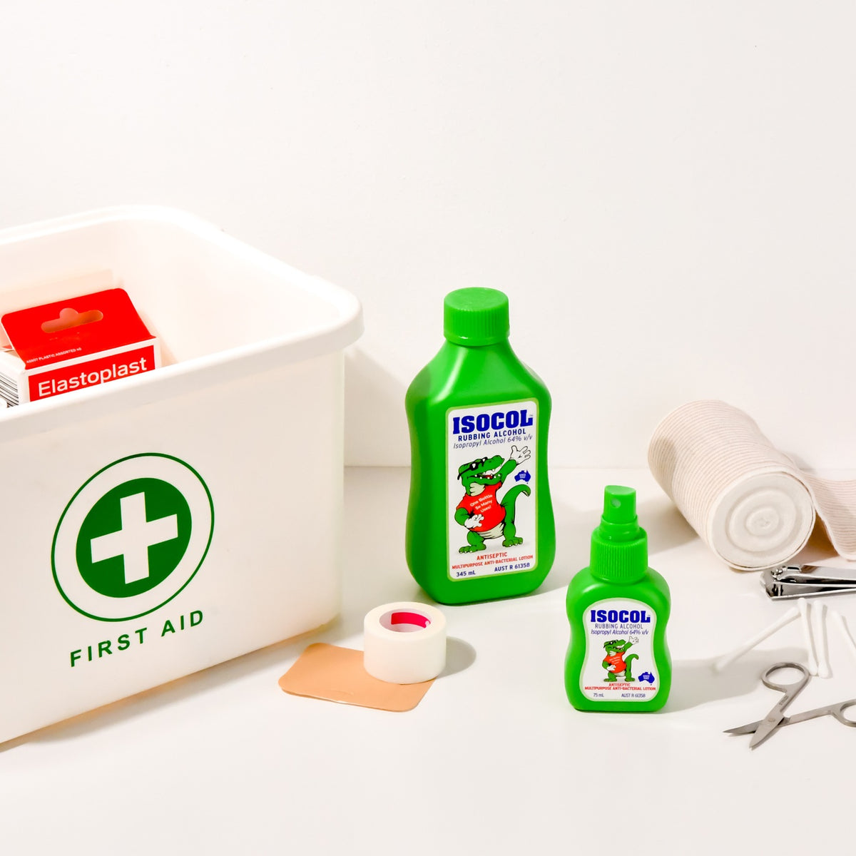 The 345ml and 75ml Isocol bottles beside a white first aid box with bandages and scissors