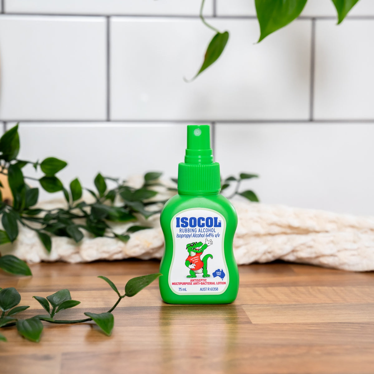 Isocol Rubbing Alcohol Antiseptic Spray 75ml bottle on a wooden bench against white tiles