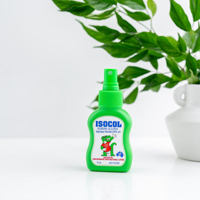 Isocol Rubbing Alcohol Antiseptic Spray 75ml bottle on a white surface beside a plant