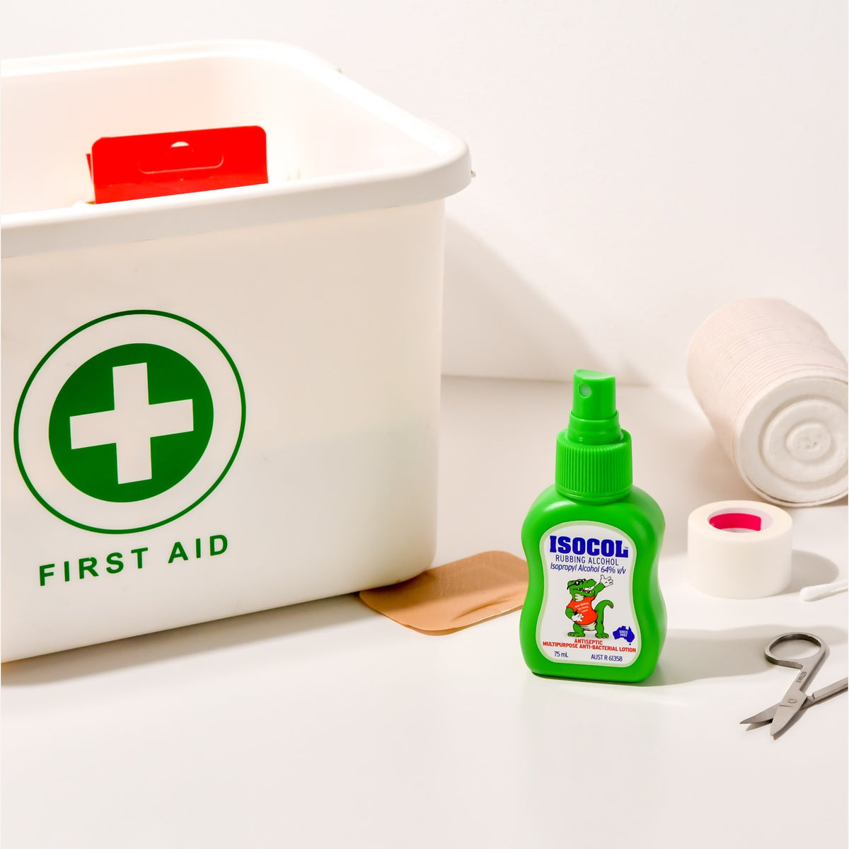 Isocol Rubbing Alcohol Antiseptic Spray 75ml beside a white first aid box, bandage and scissors