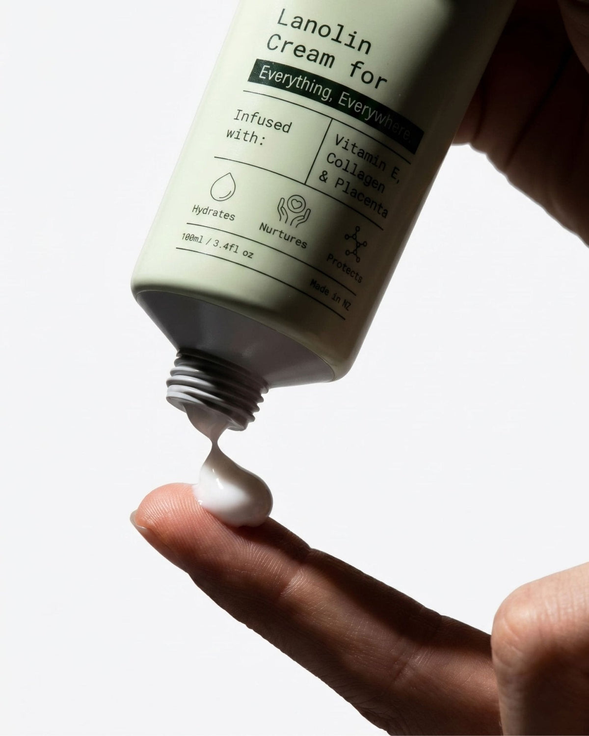 A hand squeezing PoiPoi Lanolin Cream from the tube