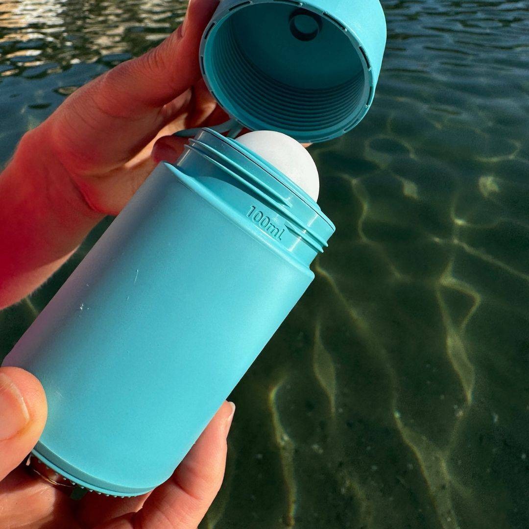 A Solmates 100ml applicator held above the water
