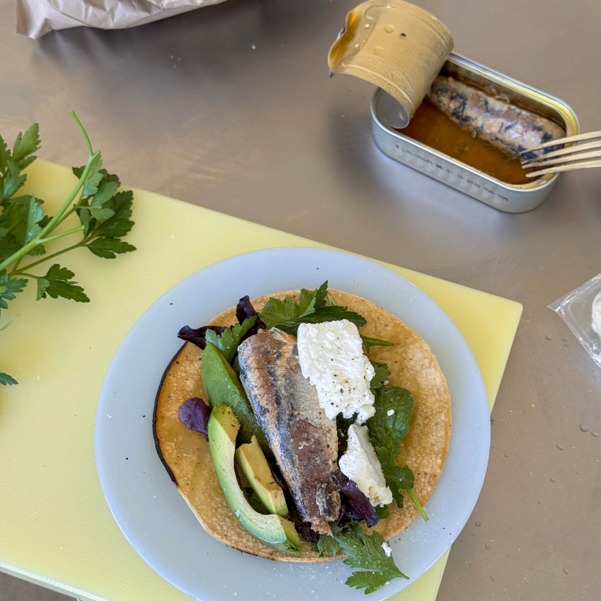 Smoky style sardines served on flatbread with herbs